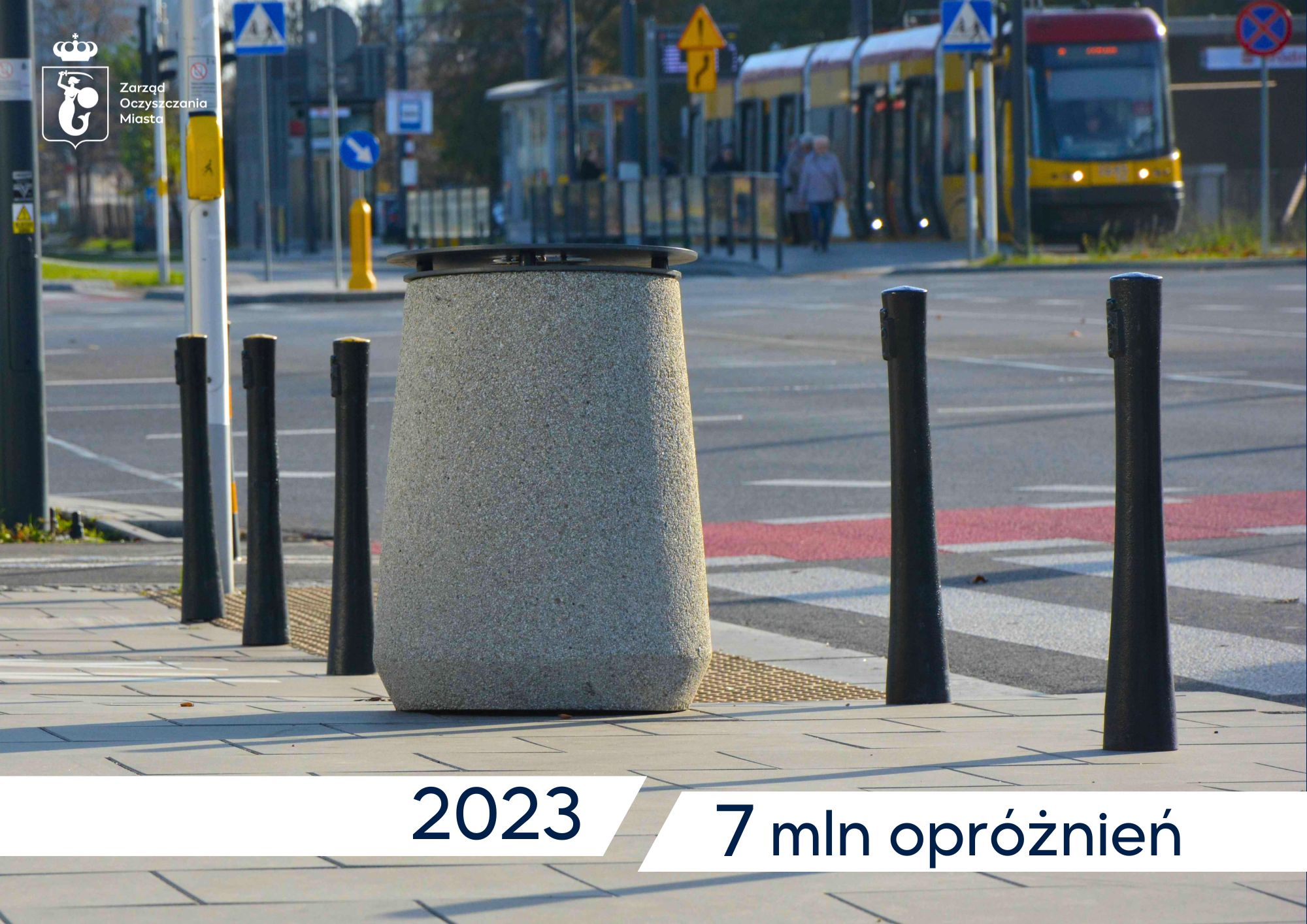Kosz uliczny, w tle tramwaj, na dole napis - 2023 7 mln opróżnień. W rogu logotyp Zarządu Oczyszczania Miasta